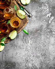 Apple juice in pitcher on the Board with a fresh , green apples.