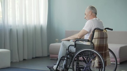 Sad sorrowful lonely old man sitting in wheelchair in his ward of nursing house - Powered by Adobe