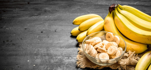 Ripe bananas with pieces of sliced bananas in a bowl . © Artem Shadrin
