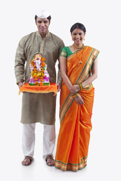 Portrait of a Maharashtrian couple with a Ganesh idol