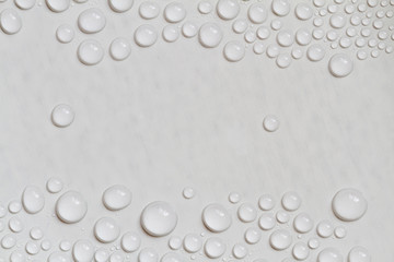 Big and small water drops on gray background with copy space. Closeup.