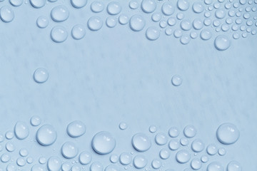 Big and small water drops on blue background. Closeup.