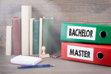 Bachelor and Master. Binders on desk in the office. Business background.