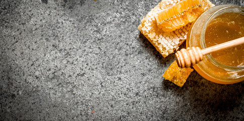 Fresh honey in jar with wooden spoon.