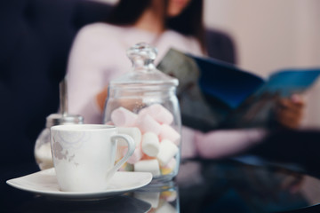 Girl guest buyer in the store expects her order with coffee and marshmallows. Concept is a treat, hospitality, a zone for clients.