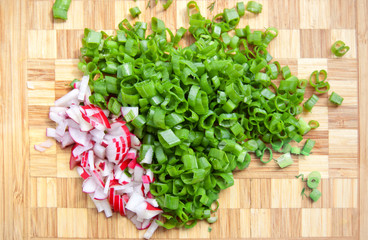 Cut radish and bunch-opinion on cutting board on white background. Top view
