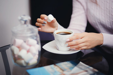 Girl guest buyer in the store expects her order with coffee and marshmallows. Concept is a treat, hospitality, a zone for clients.