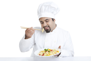 Chef eating pasta with chopsticks
