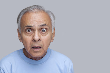 Angry old man over colored background 