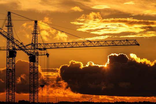 Building Cranes Against Sunset