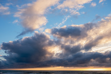 Fototapeta na wymiar Nuages et coucher de soleil sur les bords de plages de l'océan