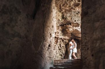Couple in love kissing in a cave. Guy and girl kissing. The couple in the cave. A lonely loving couple. Man and woman