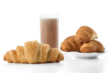 Close up studio shot of freshly baked croissants served with cacao milk isolated on white. 