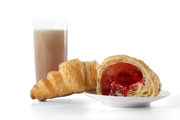 Delicious freshly baked croissant with strawberry filling served with a glass of cacao isolated on...