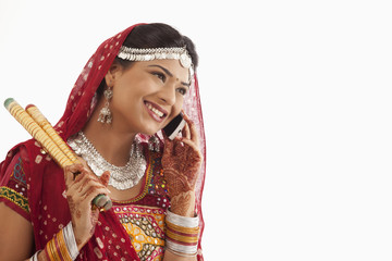 Female dandiya dancer talking on a mobile phone 