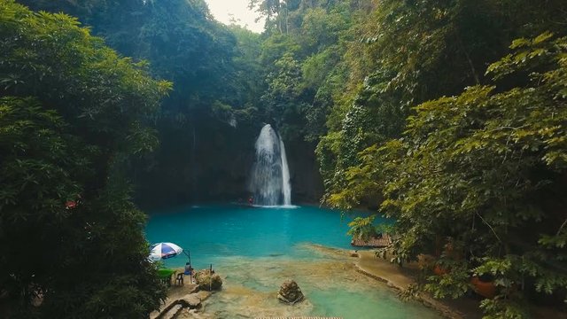 Beautiful waterfall in green forest in jungle. Tropical rain forest with waterfall.Waterfall with natural swimming pool in a mountain river canyon. Kawasan Falls. Philippines, Cebu. 4K video. Travel