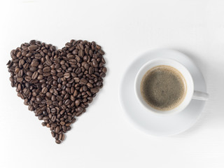 Coffee in a white cup on a white background. Heart made of coffee beans