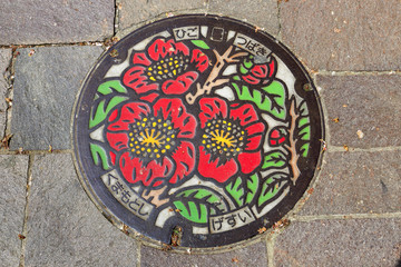 Painted manhole cover  in the street at Kumamoto