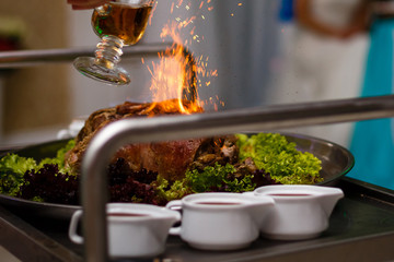 Obraz na płótnie Canvas Chef, Meat poured alcohol and set fire to