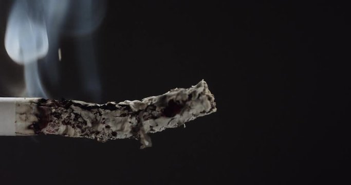 Cigarette burns in reverse, slow motion close up