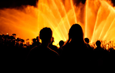 Fototapeta premium Girls silhouette in front of yellow fountain