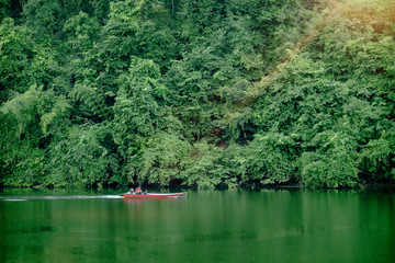 Mountain forest with rain on kwai river landscape and boat in kanchanaburi, Thailand. Natural concept