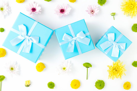 Blue gift boxes with different chrysanthemums on white background