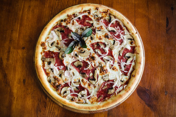 delicious pizza with meat, cheese and mushrooms