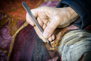 Restauro con bisturi su superficie pittorica
