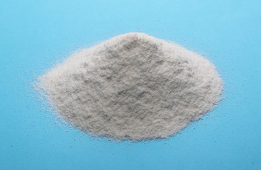 Rice flour pile isolated on blue background