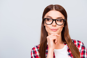 Portrait of sceptic young freelancer brown haired lady, she is in glasses, casual wear, on pure light background. So pensive and sexy