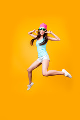 Fototapeta na wymiar Funky, happiness, dream, fun, joy concept. Very excited happy cute asian teen is jumping up, showing v signs, on bright yellow background