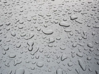Closeup drop of water on the car with grey background after rain, nature background