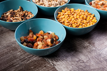 Mix of delicious different type of nuts in bowls on wooden background