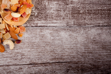 Healthy different type of nuts and sweet in wooden spoon on wooden background in studio photo