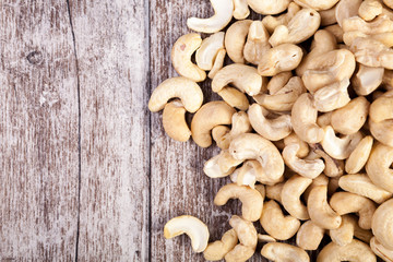 Over top view of Cashew nuts on wooden background in studio photo. Raw healthy food