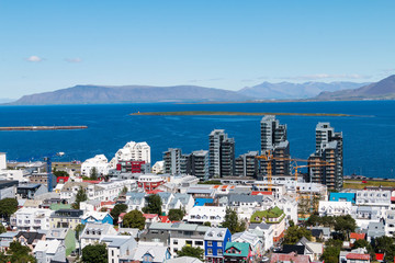 Aerial view on capital of Iceland - city of Reykjavik - ocean bay,  streets, houses, roofing,...