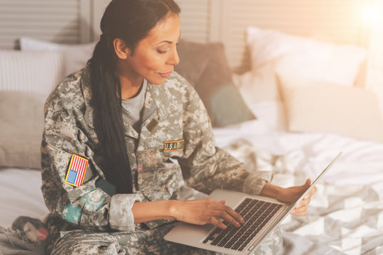 Military Woman Chatting On The Laptop In Bed