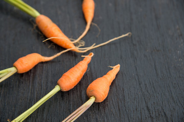 Fresh baby carrot on wood texture.