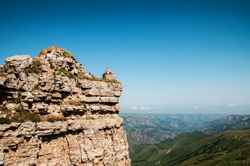 Young couple sitting on the cliff