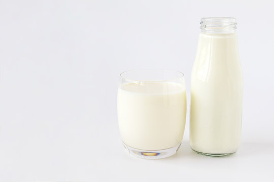 Bottle of milk and glass of milk on a white background