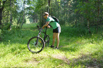 Obraz premium Biker with a mountain bike in the forest in summer