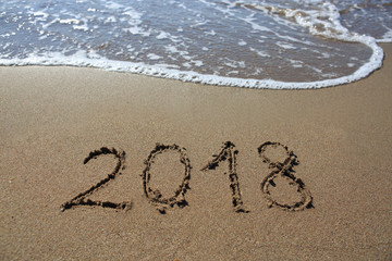 New year 2018 written in sand.
