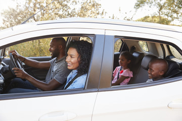 Young black family in a car smile on the road trip