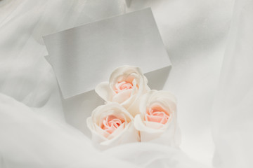 Mockup. White card on a white romantic background with flowers. Top view