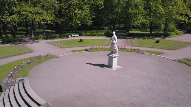 Bronze statues standing in the forest in the thicket among the trees of different gods male female statues of the Venus Zeus Cupid