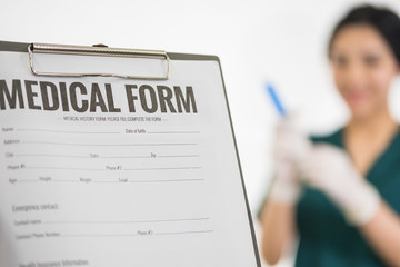 Female medicine doctor hand holding silver pen writing something on clipboard closeup. Medical care, insurance, prescription, paper work or career concept. Physician ready to examine patient and help - obrazy, fototapety, plakaty