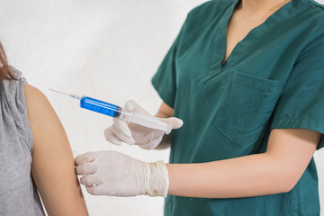 Close-up hands,nurses are vaccinations to patients using the syringe.Doctor vaccinating women in...