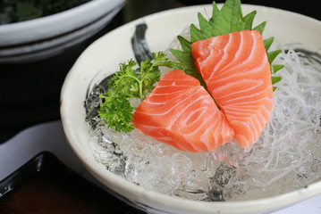 Sliced salmon raw sashimi on ice.