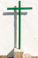 Green cross against a white wall in the Lanzarote town of Teguise